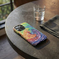 Colorful phone case on a round concrete table with a glass of water and a napkin.